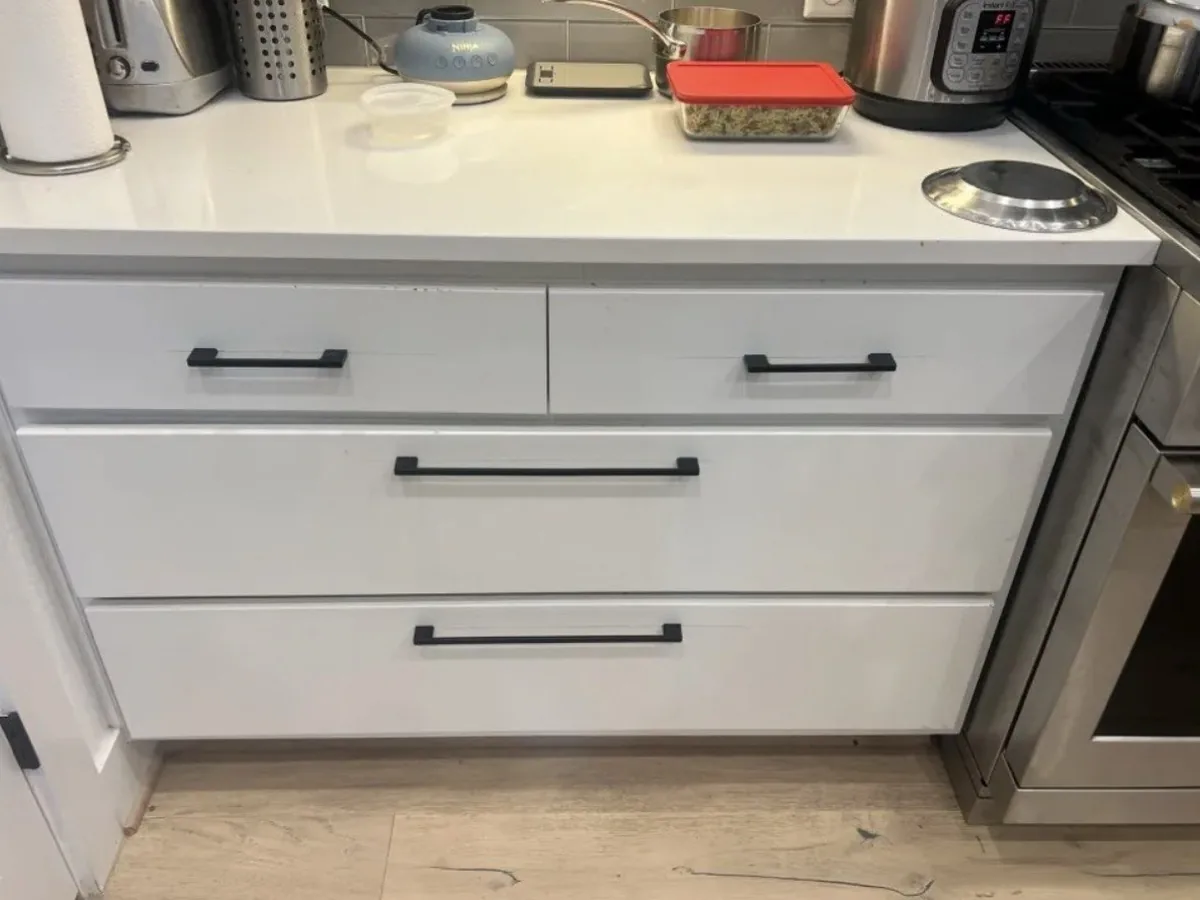 New black cabinet handles installed on kitchen drawers in a Georgetown, TX home