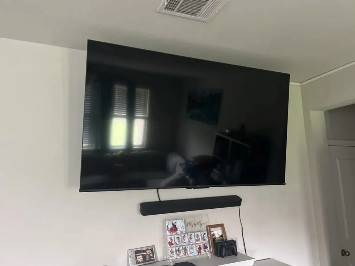 Large flat-screen TV mounted level on the wall with a soundbar in a Georgetown, TX home